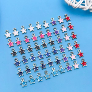Gros plan de charms étoiles colorés en émail doré pour la création de bijoux DIY