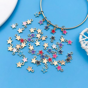 Détail de breloques étoiles colorées en émail pour bijoux DIY sur fond bleu