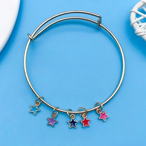 Bracelet ajustable doré avec cinq breloques en forme d'étoiles colorées sur fond bleu