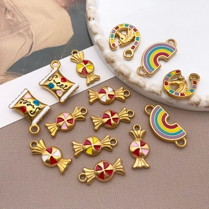 Detail of DIY jewelry charms with colorful enamel rainbow and candy cattle designs