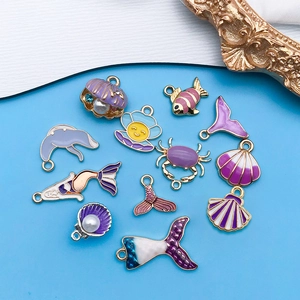 Detalle de 11 dijes marinos en esmalte púrpura y azul con sirenas y criaturas del océano