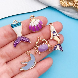 Detalle de cinco colgantes marinos de esmalte púrpura para crear joyas artesanales