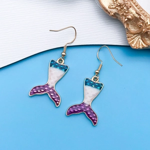 Detalle de pendientes de cola de sirena con esmalte degradado azul y violeta y escamas doradas