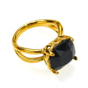 Detalle macro de anillo dorado con piedra negra cuadrada y montura de filigrana