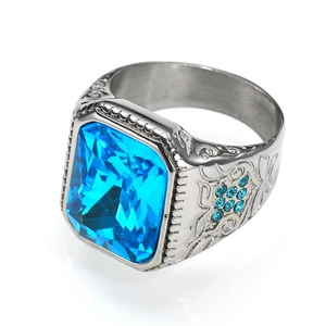 Macro shot of silver hip hop ring with large blue gem and vintage side engraving
