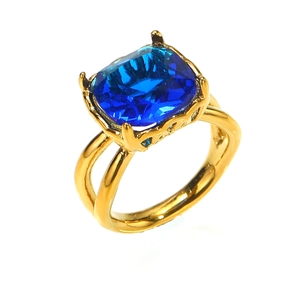 Elegante anillo de titanio dorado con un gran circón azul y un diseño de aro dividido