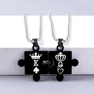 Dettaglio della collana con ciondolo puzzle a incastro con incisioni King e Queen