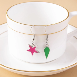 Detail of anime-inspired asymmetric earrings with pink star and green teardrop icons