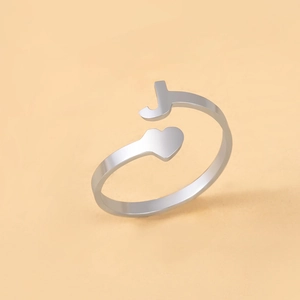 Detail eines verstellbaren Edelstahlrings in Silber mit Buchstabe J und Herzform
