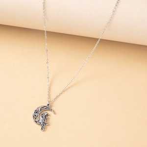 Detail of vintage silver moon and owl pendant necklace with Celtic patterns and star