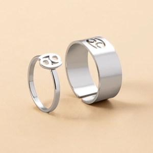 Close-up of stainless steel Cancer zodiac couple rings with polished silver finish