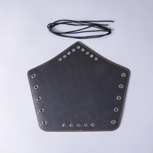 Detail view of black leather arm guard with yellow stitching and metallic rivets for archery