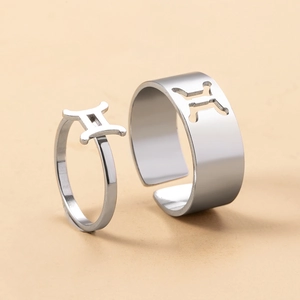 Detail of silver Gemini zodiac rings featuring cutout patterns and 3D constellation symbols
