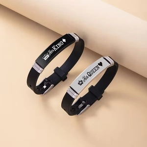 Close-up of His Queen and Her King crown engravings on black silicone couple bracelets