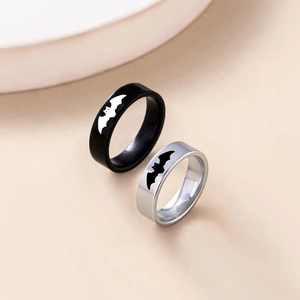 Close-up of black and silver couple rings featuring iconic batman superhero bat logos