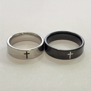 Close-up of minimalist stainless steel cross rings in silver and matte black finish