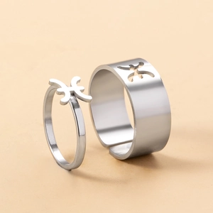 Macro shot of silver stainless steel Pisces zodiac couple rings with open adjustable bands