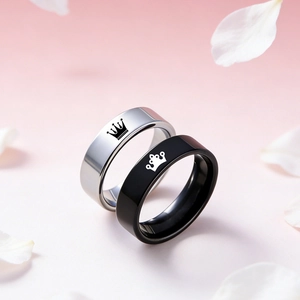 Detail of crown engraved stainless steel couple rings on a floral petal background
