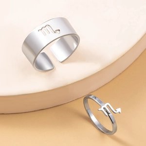 Macro view of Scorpio zodiac sign rings on a modern beige display stand