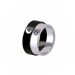 Detail of sun and moon symbols on black and silver stainless steel couple rings