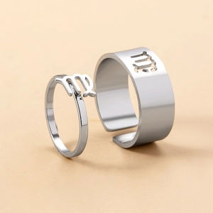 Macro detail of silver Virgo zodiac couple rings with adjustable open band design
