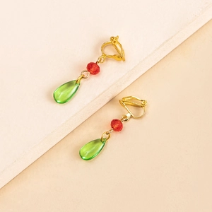 Close-up of gold U-shaped ear clips with faceted red beads and green waterdrop pendants