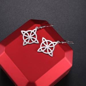 Macro shot of silver Celtic knot earrings on a red box with Viking rune details