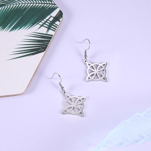 Close-up of silver Viking rune Celtic knot earrings on a lavender background