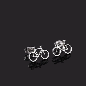 Macro shot of silver bicycle stud earrings with a sleek metallic finish on black surface