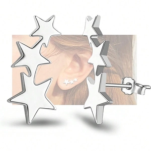 Detailed view of silver triple star earrings with a polished finish on white background