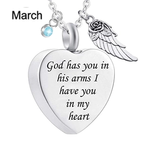 Detail of silver heart locket pendant with wing charm and blue birthstone crystal
