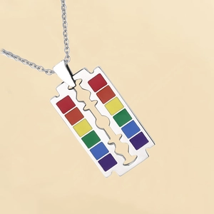 Detailed view of rainbow rainbow pride razor blade pendant on a silver steel chain necklace