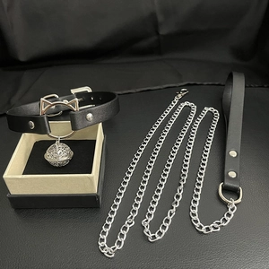 Detail of black leather collar with cat ear metal ring, silver bell and leash set