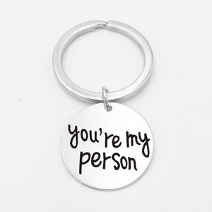 Close-up of a silver stainless steel keychain engraved with the phrase You're my person