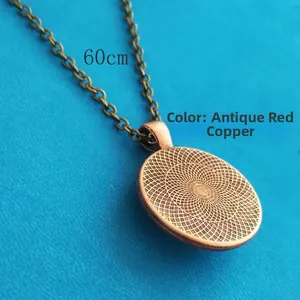Macro view of antique red copper necklace chain and circular textured pendant base