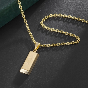 Gold bullion bar necklace with fine gold engraving on a premium black textured background