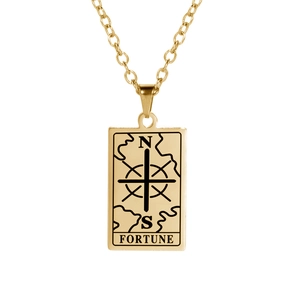 Detailed macro of golden tarot fortune pendant with engraved compass and N S letters