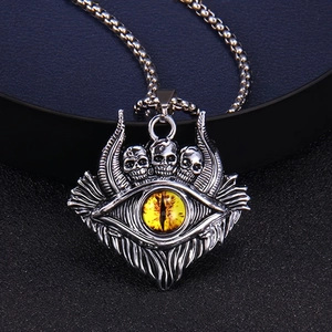 Macro shot of gothic skull pendant featuring a yellow evil eye and aged silver texture