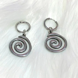 Silver swirl spiral drop earrings for men and women on a soft white plush background