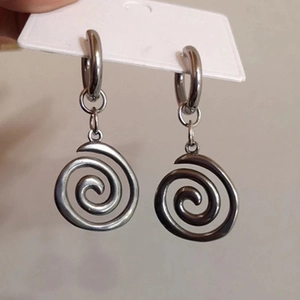 Close-up of silver swirl drop earrings featuring celestial star sun design on a display card