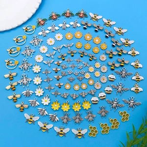Set de dijes de aleación de abeja y margarita para joyería DIY sobre fondo azul