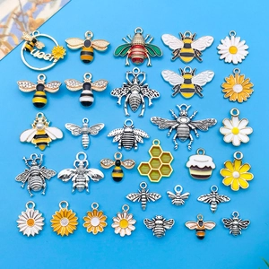 Surtido de colgantes de abeja y flor de aleación para joyería artesanal sobre un fondo azul