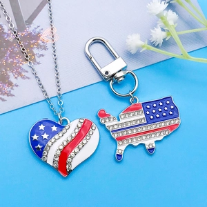 Close-up of USA flag heart necklace and map keychain with red white blue enamel and rhinestones