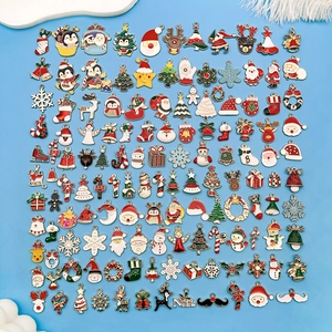 Varios colgantes navideños de esmalte con Papá Noel y renos sobre fondo azul claro