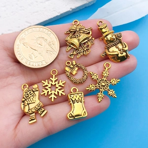 Detailansicht goldener Weihnachtsanhänger wie Weihnachtsmann und Schneeflocken mit Münz-Größenvergleich