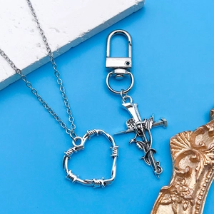 Pendentifs gothiques cœur et épée rose en argent sur fond artistique de style vintage