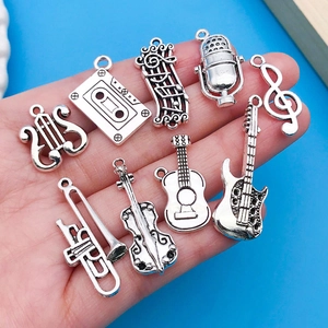 Dettaglio di ciondoli musicali in argento antico per la creazione di gioielli DIY