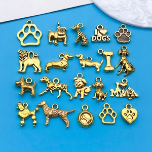 Makroansicht verschiedener vergoldeter Hunde-Anhänger und Knochen-Charms für DIY-Schmuck