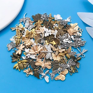 Detalle de varios colgantes de insectos de aleación para joyería DIY en fondo azul