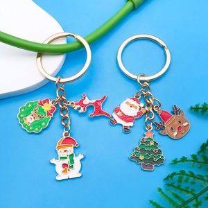 Détail de porte-clés de Noël avec Père Noël et élan en émail sur des anneaux dorés